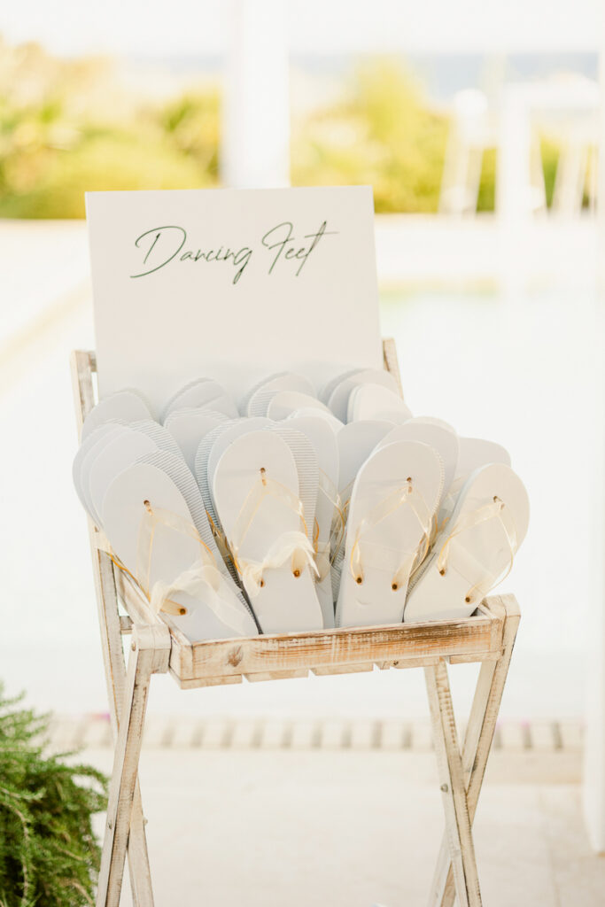 Display stand with white flip-flops and translucent straps labeled Dancing Feet outdoors.
